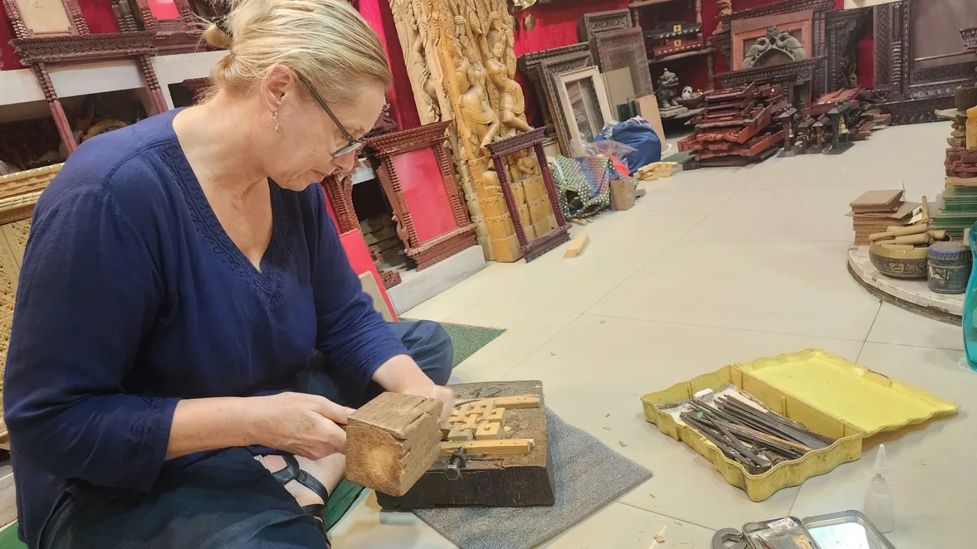 A visitor learning to carve wood at the workshop